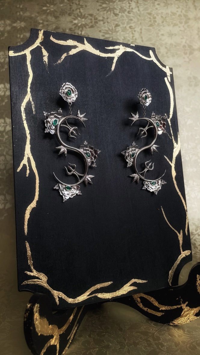 A pair of sterling silver Khetaka earrings with intricate floral designs, inspired by the khetaka symbol that represents shield that protects one from negativity