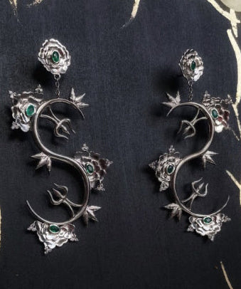 A pair of sterling silver Khetaka earrings with intricate floral designs, inspired by the khetaka symbol that represents shield that protects one from negativity